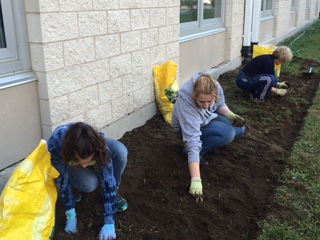 Ms. Mullins works on courtyard garden beds with seniors Jeannette Mooney and Tianna Ficarra.