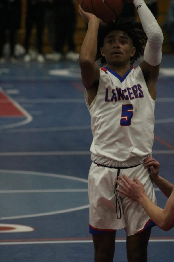 Senior, Kenny Hill, shoots against opponent, East Lyme.