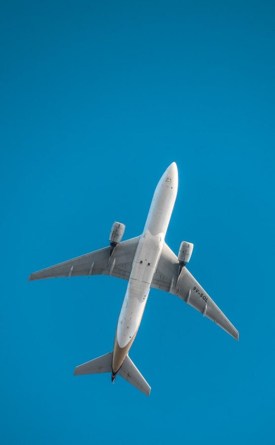 A plane flying featuring a beautiful blue sky.